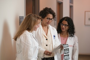 three doctors looking at a prints